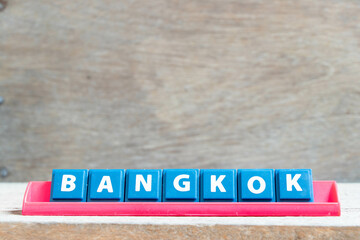 Tile alphabet letter with word bangkok in red color rack on wood background