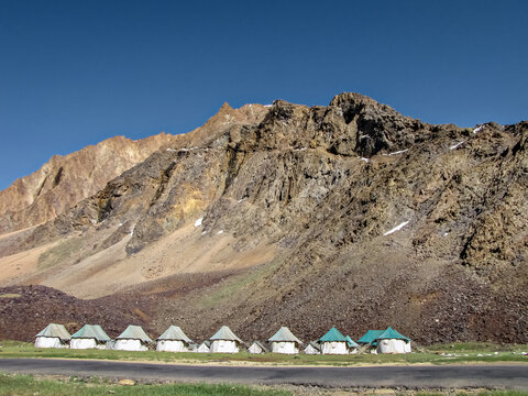 Tents for on way stay accommodation in Sarchu , with mountain and sky in background.