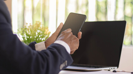 Business woman working with her phone and laptop, Happy woman using mobile phone while working with laptop.