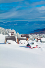 A-frame mountain houses (shelter) surrounded with meadow and trees covered with snow in winter with beautiful view	