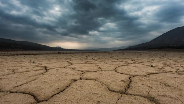 cracked land Timelapse with Dramatic clouds, lack of freshwater global warming climate change concept, Cracked soil in a desert dry land , ecological issues, water crisis, increased temperatures