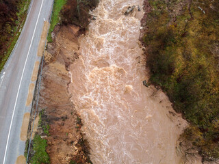 Water floods and landslide during heavy rain. Swollen river in autumn. Muddy and dirty water flows,...
