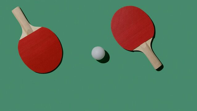 Red rackets and a white ball move on a green tennis table. 