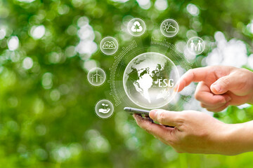 Human hand holding smartphone and pointing green earth ESG icon environmental, social governance in...