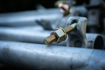 Close up of a screw. Construction site.  Workers.  House renovation with tools.  New house with new materials, stairs, sheets and house coat. Steel and iron. Tubes