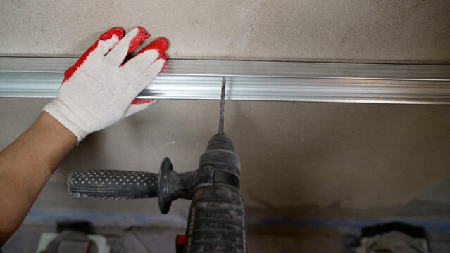 A Worker Installs A Metal Shower Enclosure Profile With A Drill. A Worker Fixes A Profile In The Bathroom.