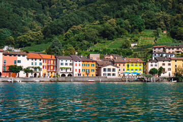 Fototapeta na wymiar Panoramic view of the ancient lakeside village of Brusino Arsizio, located at the foot of Monte San Giorgio, on the shores of Lake Lugano, Ticino, Switzerland. 
