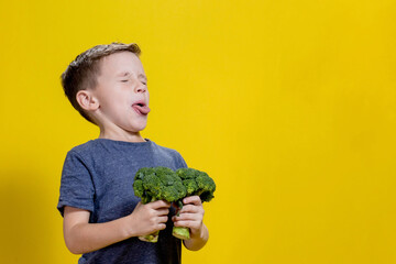 A charming little boy refusing to eat broccoli. Brootish broccoli - obrazy, fototapety, plakaty
