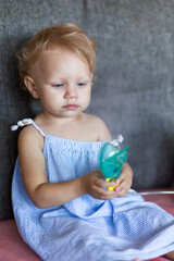 a child with snot holds a mask from a nebulizer in his hands.