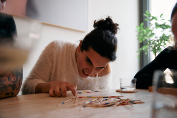 Woman playing mikado with friends