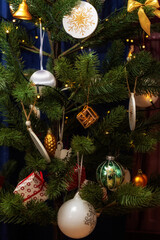 Variety of Christmas toys are hanging on the green Christmas tree on the eve of the holiday.