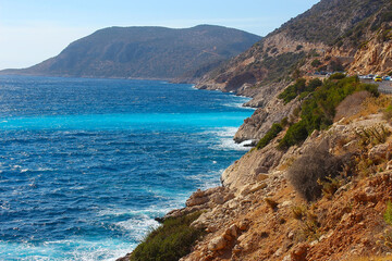 Fototapeta premium Aerial view from road of people crowd relaxing on beach. Swimming people in sea. Top view of Kaputas Beach between Kas and Kalkan