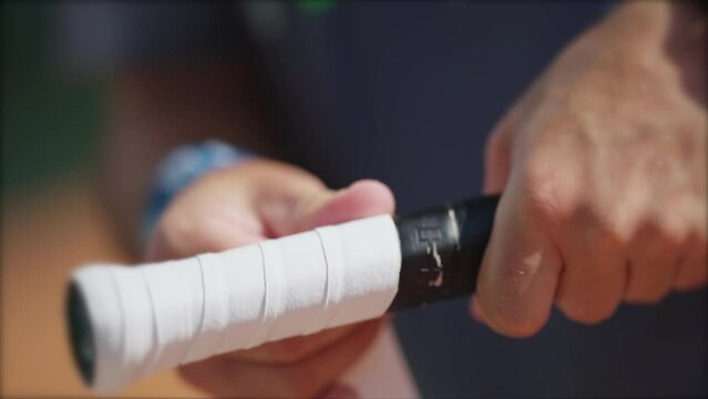 Player changing racquet tennis grip. Person replacing overgrip closeup hand renewing sport equipment