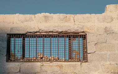 Ventana y restos de una pared en Monopoli, Italia. Ventana con marco y rejas oxidadas y la pared...