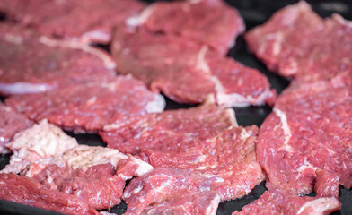 Raw pieces of meat on a baking sheet