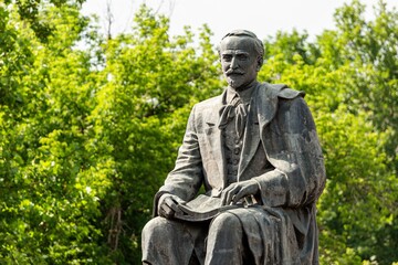 Fototapeta premium Horizontal image of statue of poet and writer Hovhannes Tumanyan in the background of trees