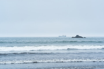 landscape with a sea rock and a sailing ship in the distance