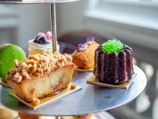 Variety of desserts in High tea set at luxury hotel in Bangkok, eg. macaron, pastry, scone.
