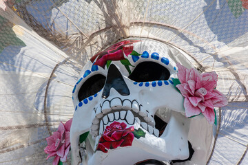 Huge skull and crossbones with regional Mexican dress for traditional Day of the Dead festivities called Catrina