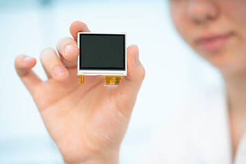 girl holding a small OLED display