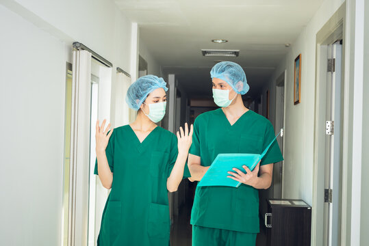 Team Of An Asian Doctors Are Looking At Report And Walking Into The Operating Room, To Surgeon And Health Care Concept.