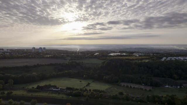 Aerial time lapse shot revealing residential area B&ouml;fingen of city Ulm and the landscape of Swabia behind the hills and forests on a cloudy morning in autumn