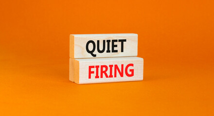Quiet firing symbol. Concept words Quiet firing on wooden blocks. Beautiful orange table orange background. Business and quiet firing concept. Copy space.