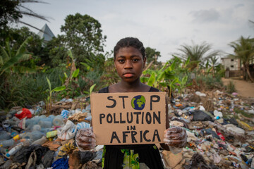 Young black african girl holding a sign written: stop pollution in Africa