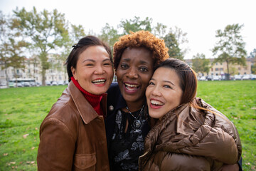 Happy multiracial women having fun at the center city park. Diversity concept