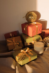Lots of packed gifts, decorations on the table in the evening light. Christmas moments. Winter holidays tradition. New Year background.