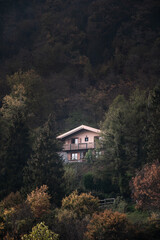 A solitary house hidden in the forest during a moody autumn day in the Northern Italy