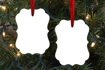 Closeup of two benelux Christmas ornaments dangling merrily from a lit-up Christmas tree