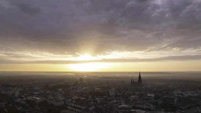 Aerial time lapse shot of Ulm city center with rising sun on a morning in autumn with colorful clouds moving through the sky 2