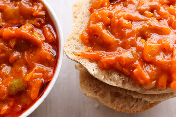 Chakalaka and braai bread. Chakalaka is a traditional South African accompaniment usually served with bread, rice, mash, pap. Made with carrots, peppers, tomato and onion 