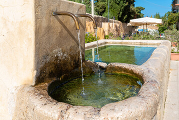 Picturesque drinking fountain on the Plaza of Scopello in the north of Sicily. A hamlet of houses clustered around a common courtyard and a public square