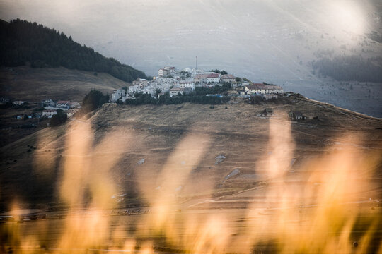 The Ruins Of The Town Of Castelluccio, Destroyed By The Earthquake, Framed Between The Wheat Crops At Sunset, Central Italy