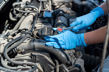 Fototapeta na wymiar Close-up shot of a professional mechanic working on a vehicle in a car service.