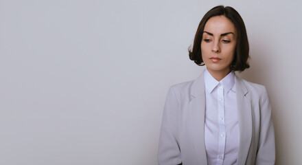 Studio close up portrait of a beautiful businesswoman in formal suit isolated on gray background
