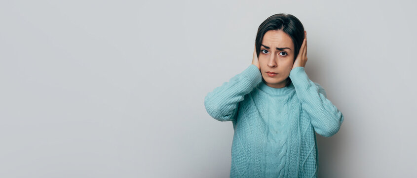 Close Up Photo Of Annoyed Stressed Young Woman Cover Ears, Feel Hurt Ear Ache, Pain, Otitis, Suffer From Loud Noise, Irritated Girl, Hear Not Listen To Noisy Music Isolated On Gray Background