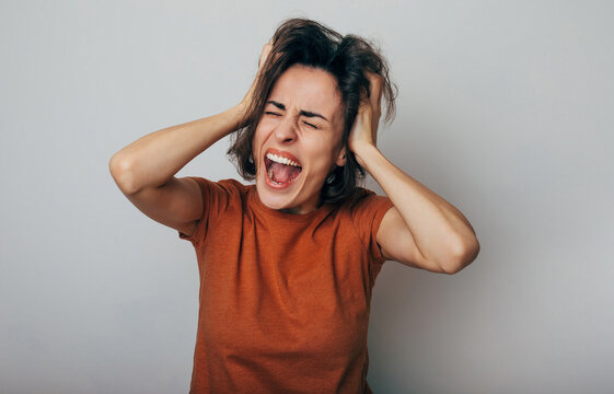 Close up shot of screaming crazy frustrated woman with anxiety, anger and depression. Very upset and emotional woman crying. Young girl with angry and furious face. Human expressions and emotions