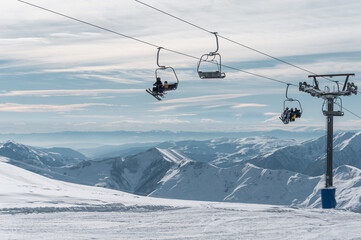Fototapeta na wymiar skiers and snowboarders on ski lift at winter at resort