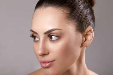 Portrait of woman with beauty face and perfect skin on gray background. Skin care. Cosmetology, beauty and spa.