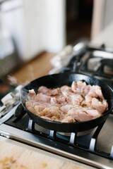 raw organic chicken cooking  in a cast iron skillet