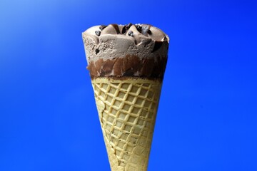 Cono de helado de chocolate sobre fondo azul