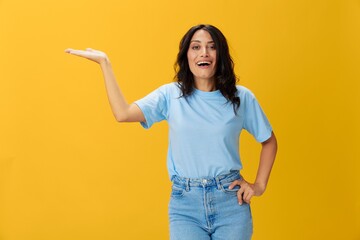 Woman signal smile with teeth emotion portrait in blue t-shirt on yellow background, hands up, surprise, lifestyle, copy space