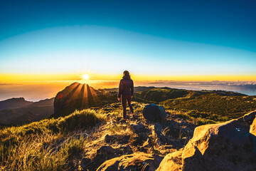 Woman enjoying beautiful mountain landscape of Pico do Ariero during sunrise. Pico do Arieiro,...