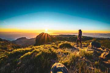 Woman enjoying beautiful mountain landscape of Pico do Ariero during sunrise. Pico do Arieiro,...