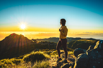 Woman enjoying beautiful mountain landscape of Pico do Ariero during sunrise. Pico do Arieiro,...