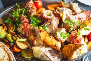 Delicious dish with a variety of fried vegetables and slices of grilled meat on the copper tray