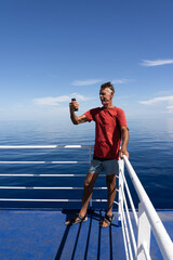 Older man talking on phone on sailboat 